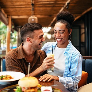 Couple smiling while enjoying meal in restaurant