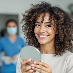 Woman smiling while holding clear aligners