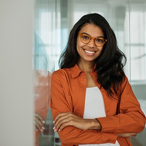 Businesswoman with glasses smiling with arms folded
