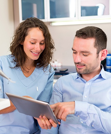 Dentist in Roswell reviewing full mouth reconstruction candidacy with a patient 