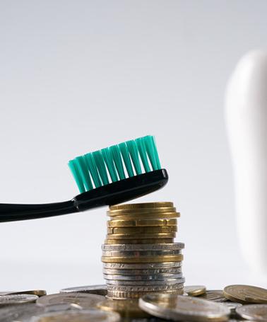 Model of a tooth leaning against stacks of coins