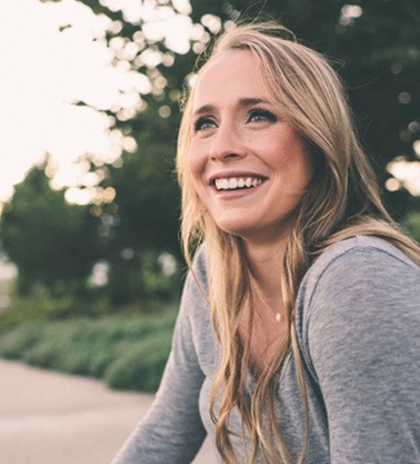 Woman sitting on the side of the road and smiling