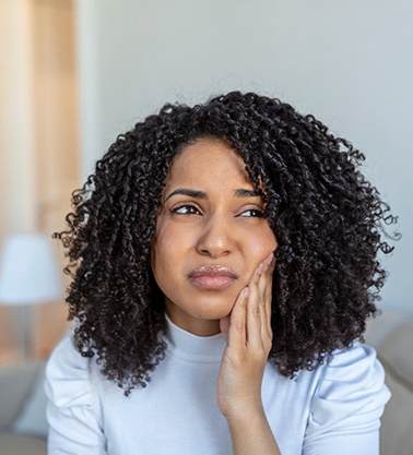 Woman experiencing toothache at home