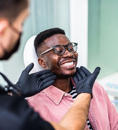 Dentist looking at smiling patient's teeth