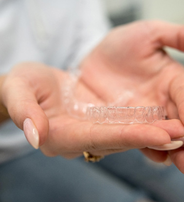 Closeup of patient holding clear aligner