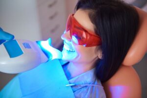 Woman having professional in-house teeth whitening treatment