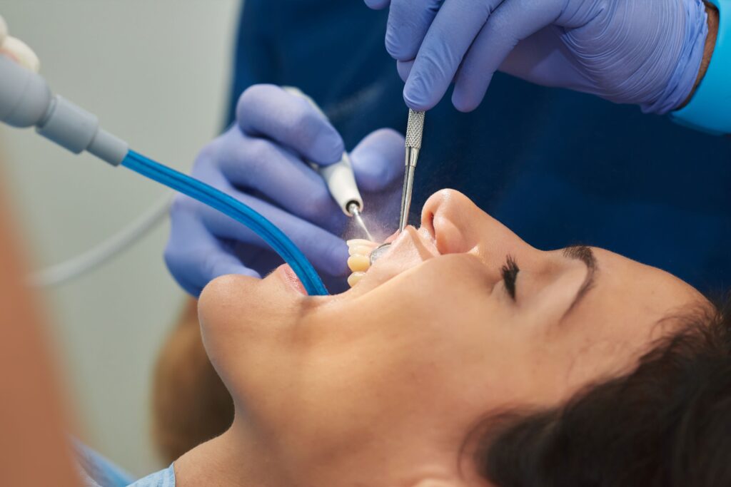 Closeup of dentist cleaning a woman's teeth